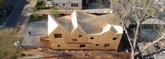 an aerial view of a house being built in the middle of trees and buildings around it