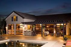 a house that has a pool in front of it and some chairs around the pool