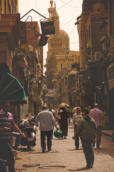 people are walking down the street in an old city