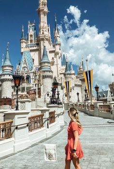 a woman is standing in front of a castle