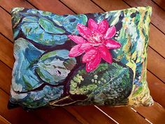 a decorative pillow with a pink flower on it