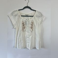 Lucky Brand Embroidered Short Sleeved Top Size Small Boho, Romantic Nwt, Retail $79.50 This Top Is White Cotton And Features Beautiful Beige Embroidery On The Front, Button Up Front, Short Sleeves, And Is Lightweight. A Lovely Top For Warm Weather. Relaxed Fit Floral Embroidery Blouse For Day Out, Relaxed Fit Blouse With Floral Embroidery For Day Out, Elegant Floral Embroidery Top For Vacation, Elegant Floral Embroidered Top For Vacation, Casual Embroidered Short Sleeve Top For Daywear, Casual Cream Top With Floral Embroidery, Cream Tops With Floral Embroidery, Feminine Embroidered Tops For Day Out, White Short Sleeve Embroidered Top For Daywear