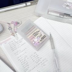 an open notebook and pen sitting on top of a desk next to a computer keyboard