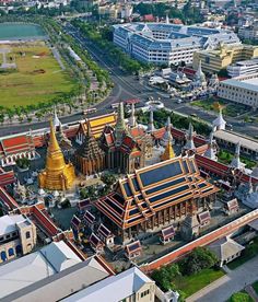 an aerial view of a city with many buildings and large gold spires on top