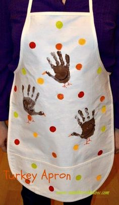 a person wearing an apron with handprints on it and the words turkey apron