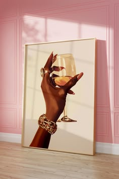 a woman's hand holding a wine glass in front of a pink wall