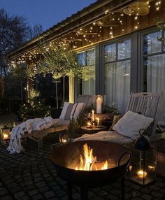 a fire pit sitting in the middle of a patio next to a building with lots of lights on it