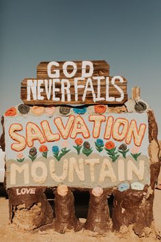 a sign that says god never falls salvation mountain