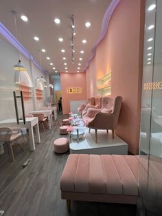 the interior of a salon with pink chairs and stools