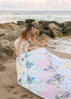 a woman on the beach with a quilt