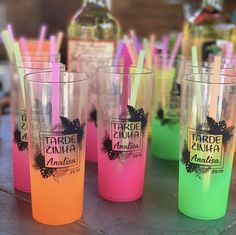 there are many different colored cups with straws on the table next to each other