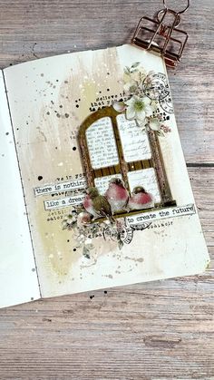 an open book with flowers on it and some scissors next to the pages that have been altered