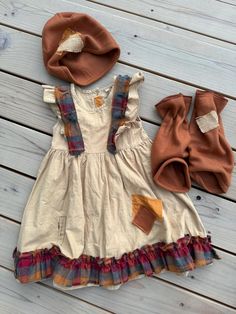 a dress and hat sitting on top of a wooden floor