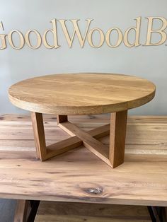 a round wooden table sitting on top of a wooden bench next to a sign that says goodwood blvd