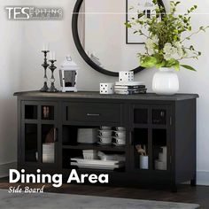 a black buffet table with plates and cups on it in front of a round mirror