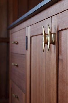 a wooden cabinet with brass handles and knobs