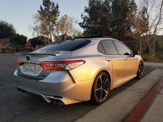 a silver car is parked on the side of the road