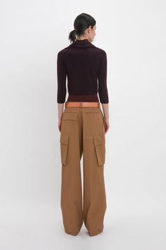 One of Victoria’s collection highlights, these loose-fitting cargo trousers bring the military-inspired style up to date with the house’s signature elevated detailing. Tailored from 100% cotton, they have a modern relaxed silhouette with traditional five-loop waistband and pockets at the side of each leg. Contrasting red bar tacks on the left back pocket flap, white stitching on the right back welt pocket and dart details at the front knee of both legs add visual interest. Victoria Beckham Relax Chic Trousers With Cargo Pockets, Luxury High-waisted Cargo Pants With Side Pockets, Luxury High-waisted Cargo Pants With Patch Pockets, Military Style Cargo Trousers With Pockets, Double Layer Top, Luxury Five-pocket Cargo Trousers, Polo Neck, Military Inspired, Cargo Trousers