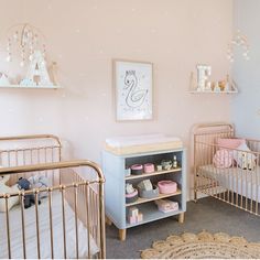 two baby cribs in a pink and white nursery