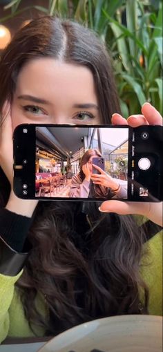 a woman taking a selfie with her cell phone