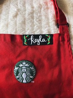 a red starbucks bag sitting on top of a white blanket