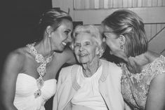 three women are laughing together in black and white