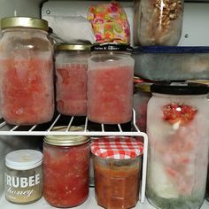 some jars filled with food sitting on top of a refrigerator