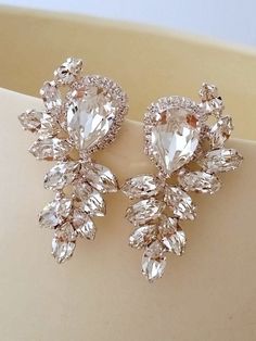 two pairs of crystal earrings on top of a table