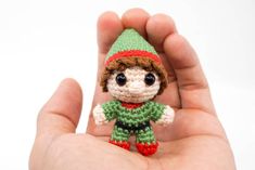 a small crocheted elf doll in the palm of someone's left hand