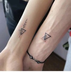 two people with matching tattoos on their arm and wrist, both holding each other's hands