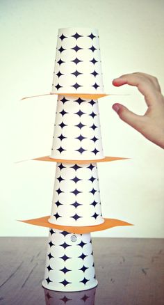 a hand is reaching for a paper cone with black and white designs on it,