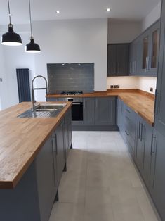 an empty kitchen with wooden counter tops and stainless steel appliances