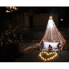 a teepee is lit up with fairy lights