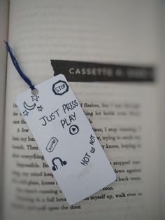 an open book with a tag that says just press play