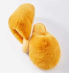 a pair of yellow slippers sitting on top of a white floor next to each other