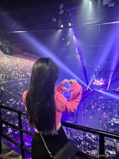 a woman standing in front of a crowd at a concert