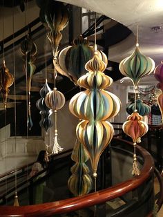 many colorful lights hanging from the ceiling in a room with glass balconies and railings