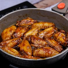 chicken wings cooking in a pan on the stove