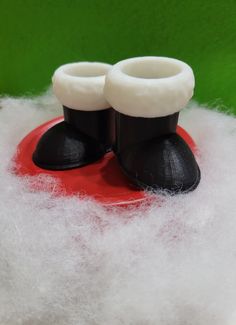 a pair of black and white shoes sitting on top of a pile of white wool