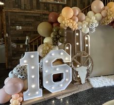 balloons and lights are arranged around the number 16 sign in front of an entrance to a restaurant