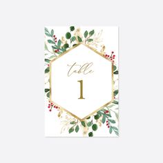 a table number card with greenery and gold foil