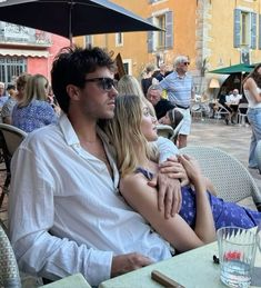 a man and woman sitting under an umbrella