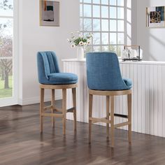 two blue bar stools sitting next to each other on top of a hard wood floor