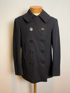 Vintage 1940s WWII era Navy Peacoat Size 38 10-button with chin strap and corduroy-lined hand warmer pockets. Fully lined. Tight fine woven wool for greater warmth. Great condition. Have some small holes. See photo. Size 38 20" across the chest 19" shoulder to shoulder  25" shoulder seam to cuff  31" from back neckline to hem Fall Pea Coat With Buttons For Tailoring, Fitted Winter Peacoat With Buttons, Fitted Peacoat With Buttons For Winter, Solid Pea Coat With Buttons For Cold Weather, Classic Fitted Pea Coat With Snap Buttons, Fitted Black Peacoat With Buttons, Classic Fall Pea Coat With Covered Buttons, Vintage Pea Coat With Double Button Closure For Fall, Retro Workwear Pea Coat With Buttons