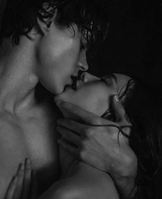 a man and woman kissing in the dark with water all around them on their backs