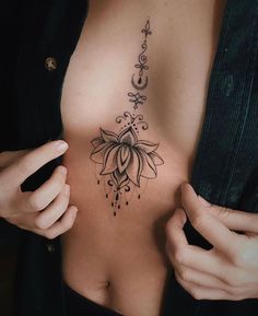 a woman's breast with a flower tattoo on her left side ribcage