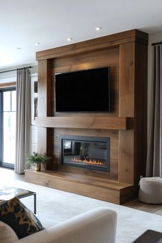 a living room with a television mounted on the wall and a fire place in front of it