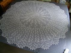 a large white doily sitting on top of a bed