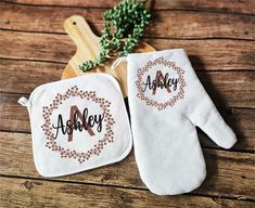 two oven mitts sitting on top of a wooden table