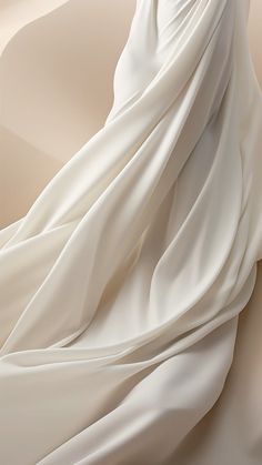 a woman in a white dress standing on top of a sand dune with her arms wrapped around her waist